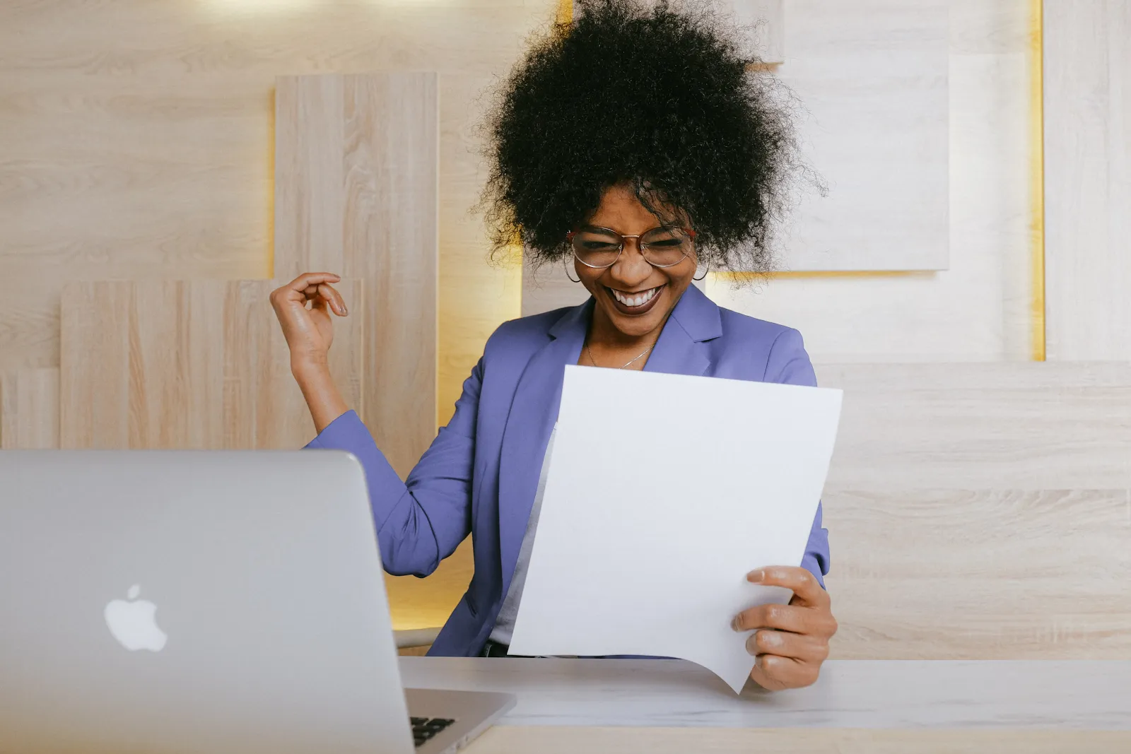Black businesswoman celebrating the success of her product research methods in front of a laptop